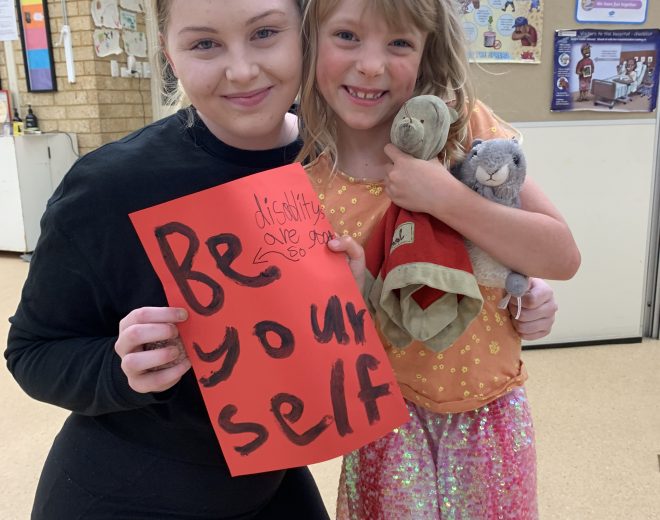 girl with disability holding sign